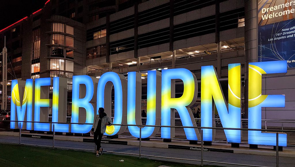 Standing next to Melbourne sign at Melbourne Airport